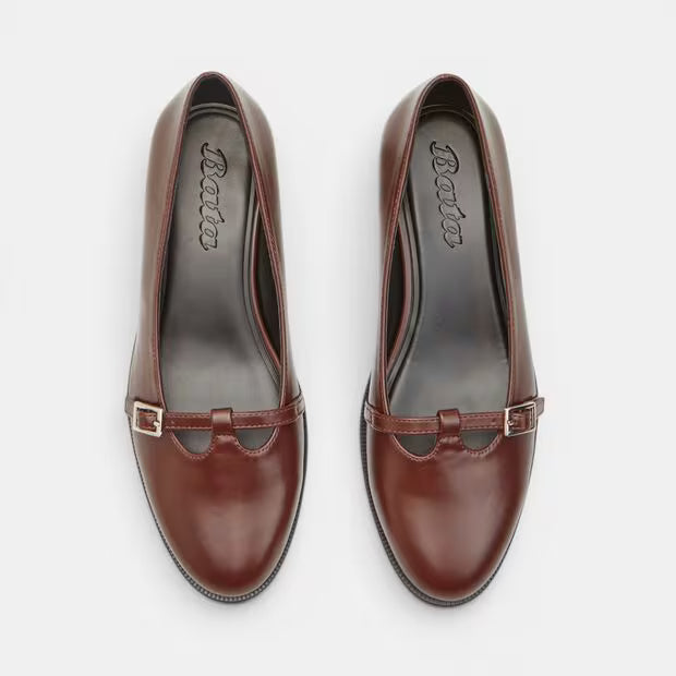 Brown leather block heel pumps with silver-tone buckle detail and stitched toe.