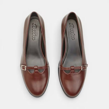 Brown leather block heel pumps with silver-tone buckle detail and stitched toe.