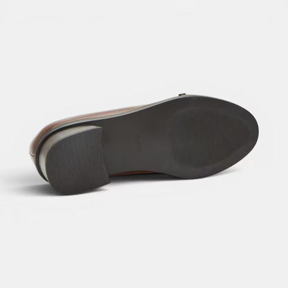 Brown leather block heel pump outsole view with dark rubber tread and heel.